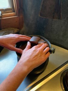 At a tour of the Wharton Esherick house, a close-up photo shows hands examining the carved wooden lid of a steel pot. Photo courtesy of Philly Touch Tours.